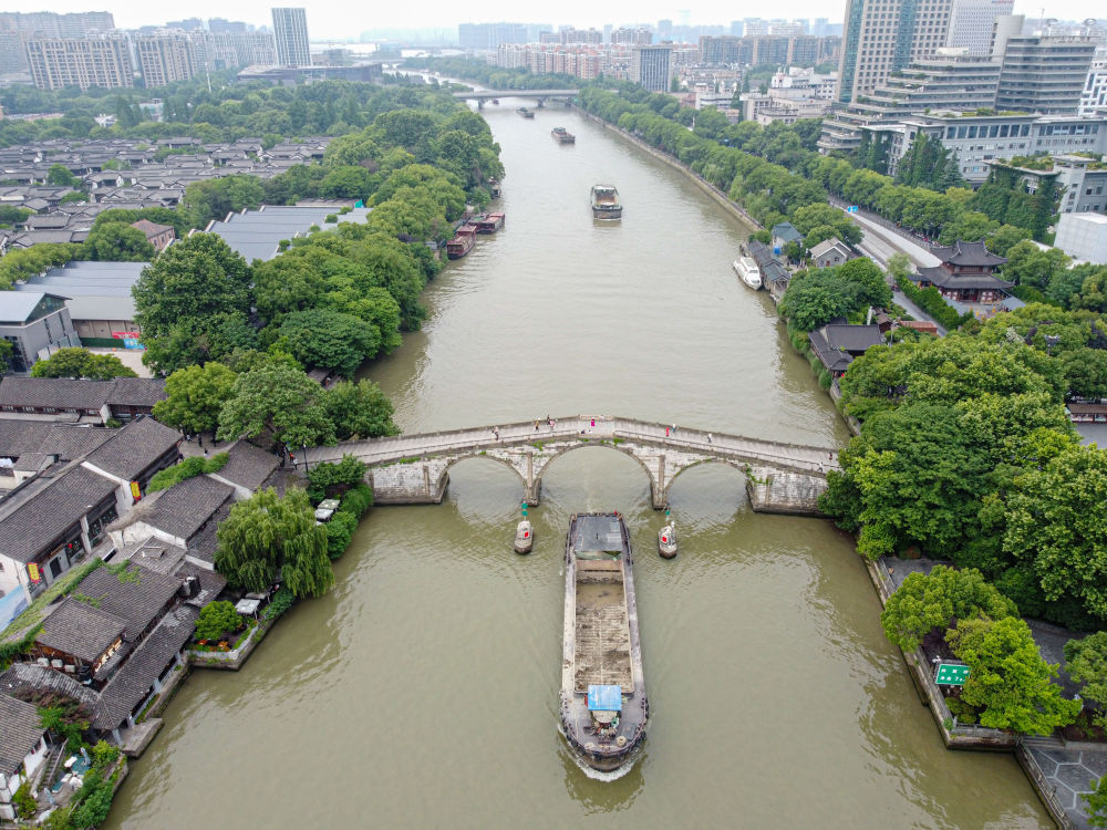 5月27日，一艘貨船駛過(guò)京杭大運(yùn)河南端標(biāo)志建筑杭州拱宸橋。(無(wú)人機(jī)照片)新華社記者江漢 攝