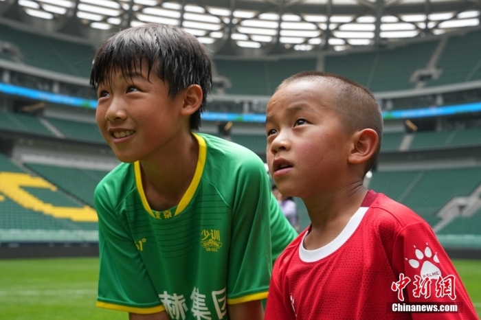 圖為北京國安小球員陳小北和7歲的俄金仁增在一起觀看場內(nèi)播放的紀(jì)錄片。<a target='_blank' href='/' _fcksavedurl='/'><p  align=