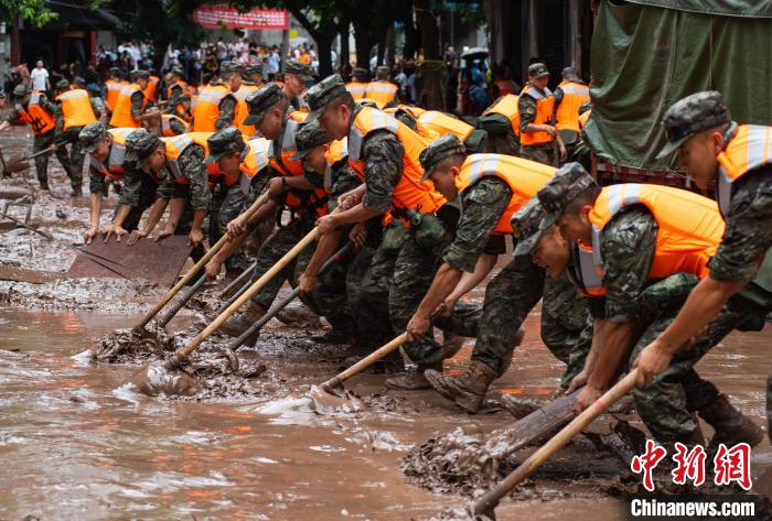 7月4日，萬州區(qū)五橋街道，武警官兵清理街道上的淤泥。　冉孟軍 攝