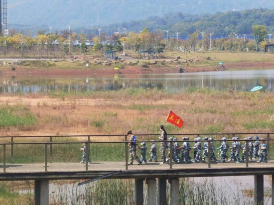 　　10月24日，秋游的幼兒園小朋友在老師帶領(lǐng)下走在清水塘公園里的木橋上。本報(bào)記者 常雯宜攝