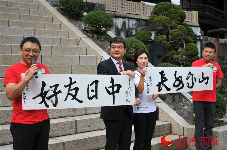 東京中國文化中心主任羅玉泉展示其為本次活動書寫的題詞“中日友好，山高水長”。人民網(wǎng) 蔣曉辰攝