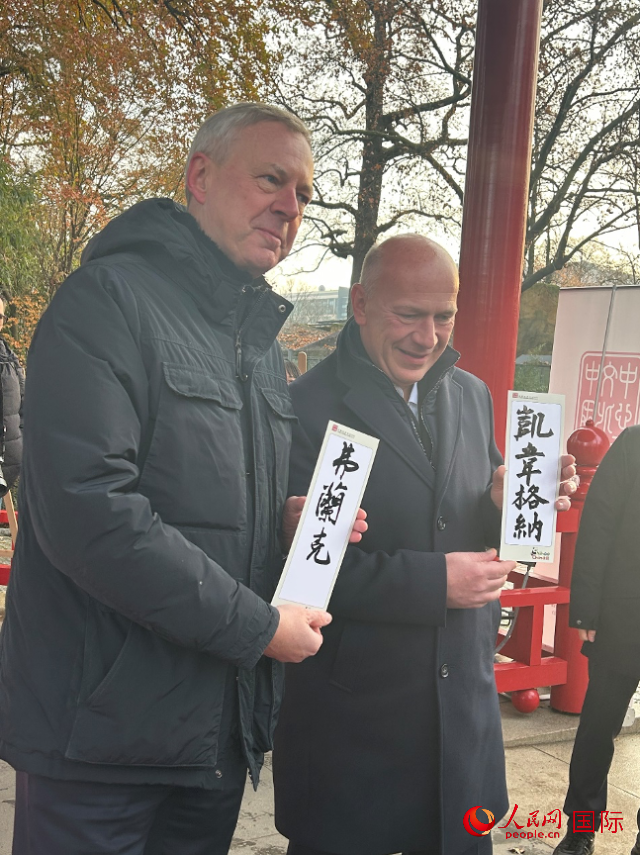 柏林市長韋格納（右）、動物園監(jiān)事會主席布魯克曼（左）手持中國文化中心工作人員現(xiàn)場手書的中文名字。人民網(wǎng)記者 徐馨攝