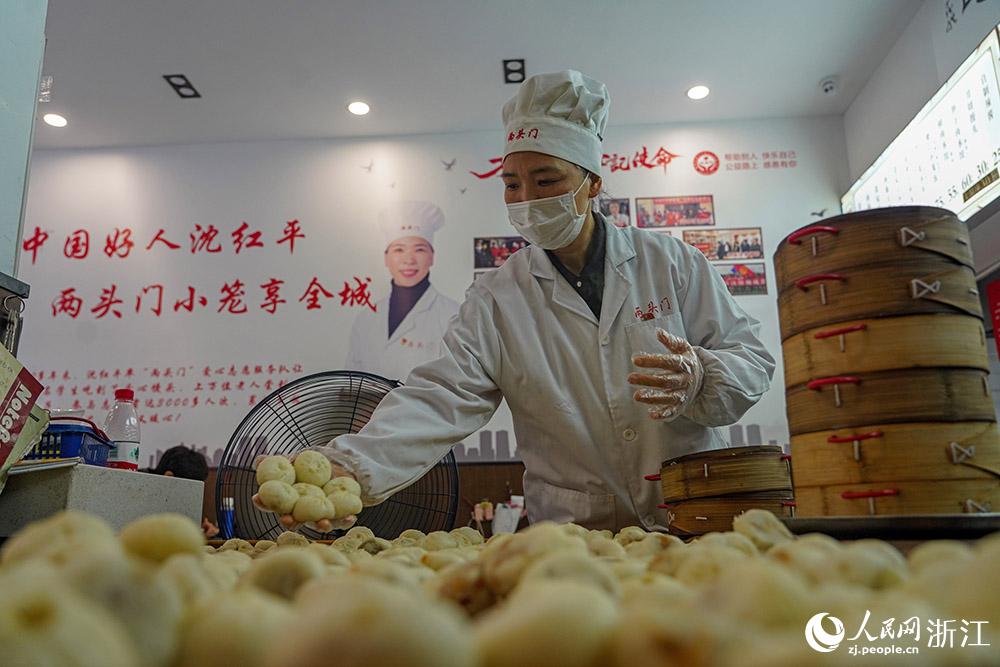 3月31日，在浙江省嵊州市甘霖鎮(zhèn)，嵊州小吃從業(yè)者沈紅平把蒸熟的小籠包晾涼，打包冷藏售賣(mài)。人民網(wǎng) 章勇濤攝