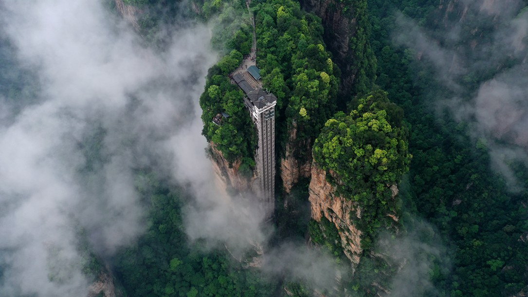 位于張家界武陵源景區(qū)的百龍?zhí)焯蓁偳对谠旗F繚繞的峰林間，雄偉壯觀。吳勇兵攝