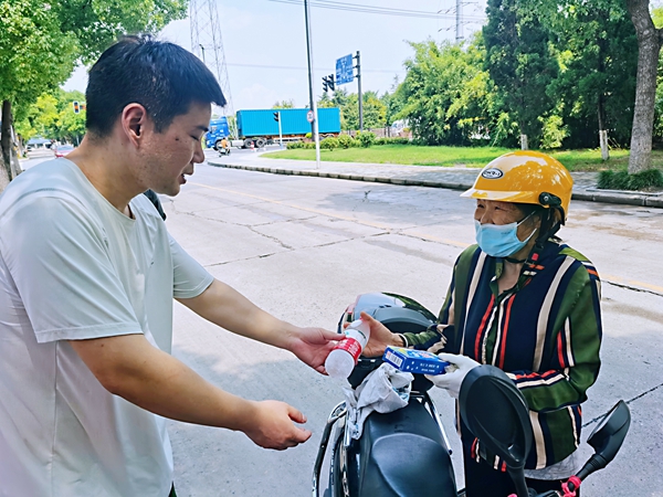 何超為過路的老人送上礦泉水和冷飲。人民網(wǎng)記者 王繼亮攝