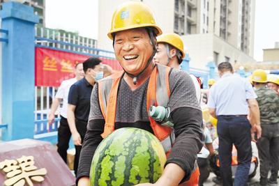 近日，石家莊市橋西區(qū)總工會到中建四局河北分公司某項目工地為一線職工發(fā)放防暑慰問品。圖為領到防暑慰問品的建筑工人露出開心的笑容。 省總工會供圖