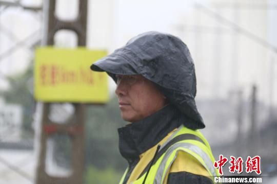 蘭州西工務(wù)段蘭州線路車間防護(hù)員雨中巡查。　王光輝 攝