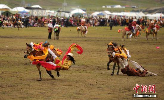 8月4日，四川理塘“八一”賽馬場(chǎng)上演一場(chǎng)精彩的馬術(shù)競(jìng)技比賽，引來(lái)上萬(wàn)民眾和游客觀賽。圖為牧民騎手進(jìn)行五彩凌空競(jìng)技。 中新社記者 劉忠俊 攝