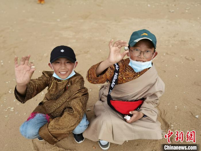 圖為西藏青少年在海邊拾貝殼。西藏航空 供圖