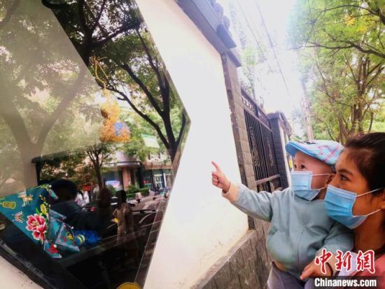 圖為蘭州市民在街頭觀賞刺繡和刻葫蘆的非遺展示。(資料圖) 史靜靜 攝