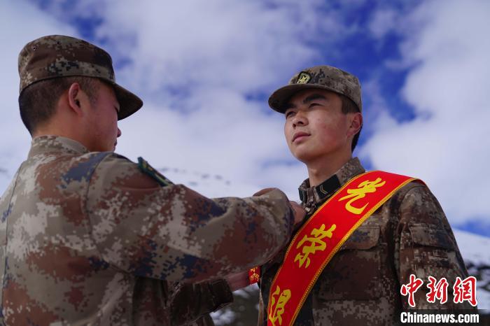 排長王朝偉(圖左)給退伍老兵佩戴大紅花。　西藏山南軍分區(qū)某團(tuán)供圖