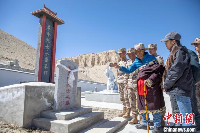 圖為在西藏阿里地區(qū)札達縣烈士陵園，82歲的次仁南杰老人為軍民代表講述新舊西藏的變化?！詵| 攝