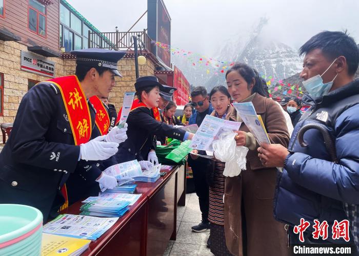 圖為山南玉麥邊境派出所民警為轄區(qū)群眾發(fā)放法律知識(shí)宣傳單?！＄婗?　攝