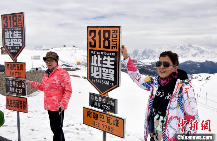 圖為5月14日，西藏林芝色季拉山觀景臺，游客與南迦巴瓦峰合影。　李林 攝