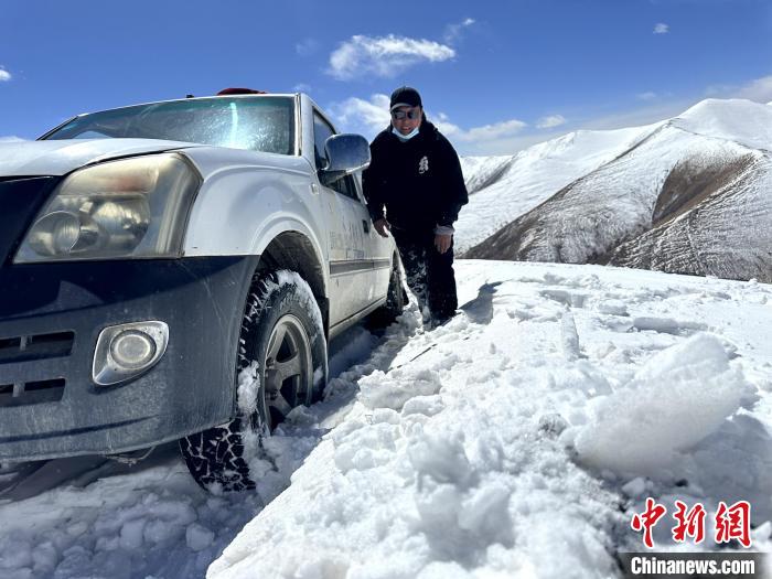 圖為生態(tài)管護人員準備在雪地推車?！《“瓦_杰 攝