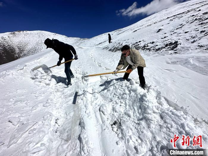 圖為生態(tài)管護人員在巡護道路上清雪。　丁巴達杰 攝