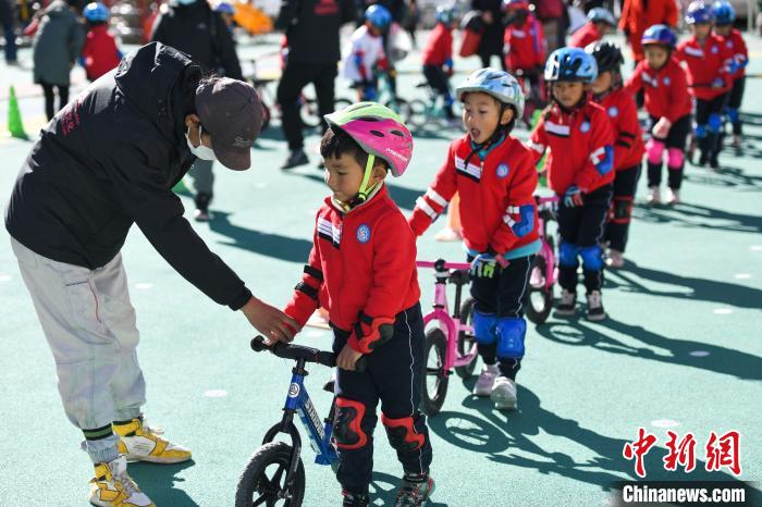 圖為拉薩市實驗幼兒園孩子們在教練的指導(dǎo)下練習(xí)滑步車。　何蓬磊 攝