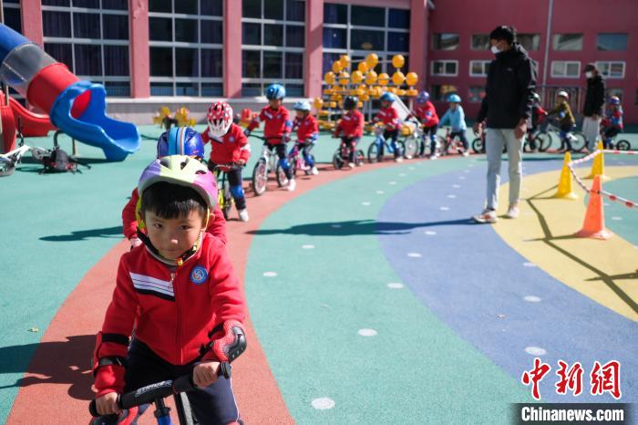 圖為拉薩市實驗幼兒園孩子們在教練的指導(dǎo)下練習(xí)滑步車。　何蓬磊 攝