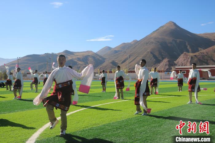 圖為青海師范大學(xué)附屬玉樹實驗學(xué)校學(xué)生在綠茵場跳起囊謙古舞—卓根瑪。　程雨 攝