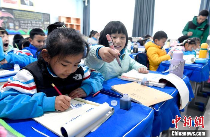 3月14日，西藏拉薩市第一小學(xué)一年級六班學(xué)生白瑪朗珍(圖左)在藏語文課上書寫藏文?！±盍?攝