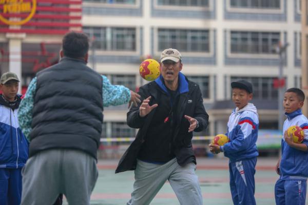 在高原上教孩子們打手球，“慢慢兒來，甭著急！”