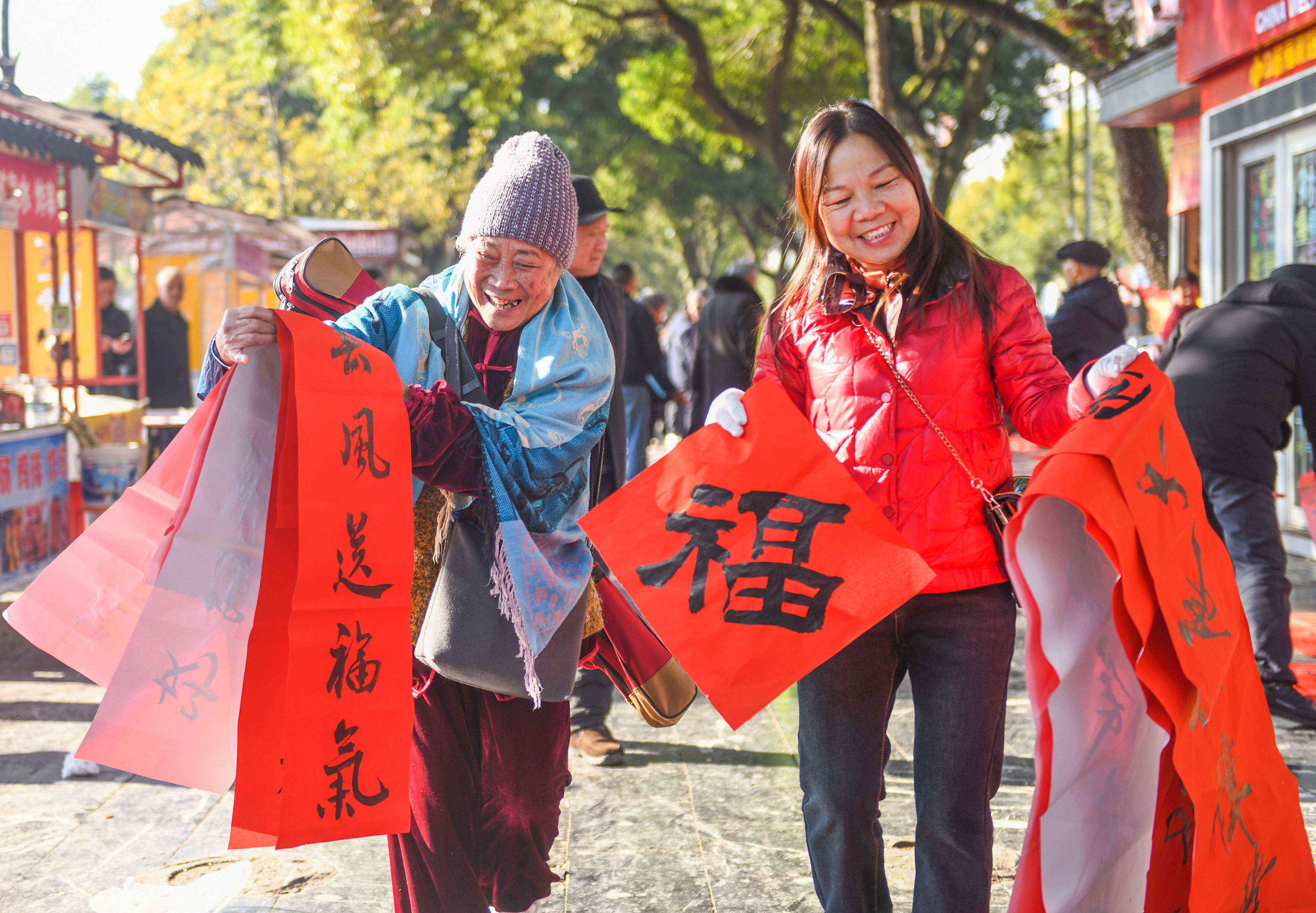 2025年1月13日，在湖南省永州市道縣西洲公園義工崗亭，市民們領到了書法志愿者為大家書寫的春聯(lián)。