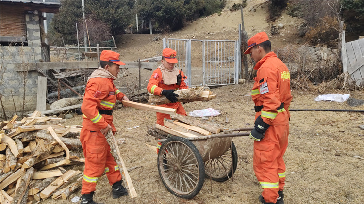 圖為李慶正帶著指戰(zhàn)員們幫助駐地居民整理木柴.jpg