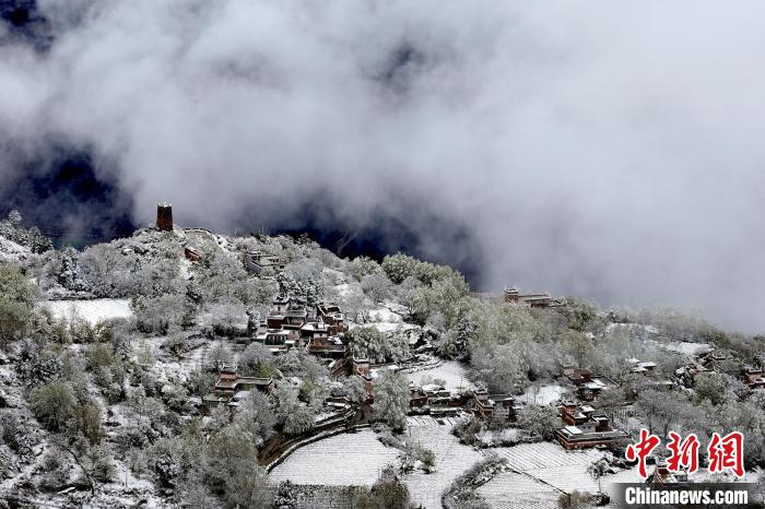 雪后的藏寨和碉樓構(gòu)成美麗的雪景?！〗党鯘衫?攝