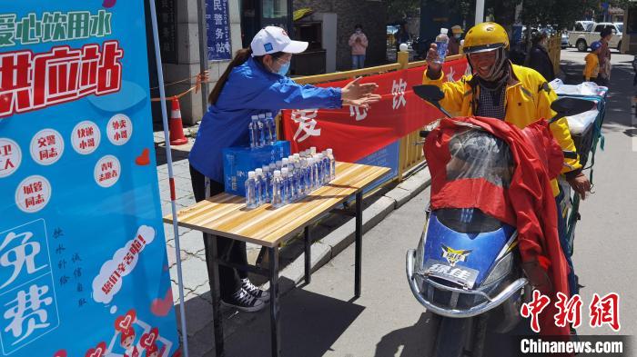 圖為近日，西藏自治區(qū)青年志愿者協(xié)會(huì)志愿者在拉薩街頭向快遞員送水。西藏自治區(qū)青年志愿者協(xié)會(huì) 供圖