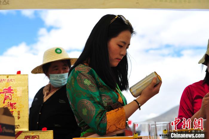 圖為拉薩市民在特色農(nóng)畜產(chǎn)品展示展銷會(huì)上選購商品?！垈?攝