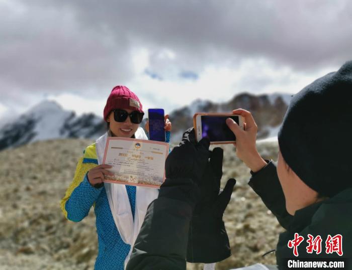 圖為5日，登頂洛堆峰的登山者獲得西藏自治區(qū)登山協(xié)會頒發(fā)的登頂證明?！垈?攝