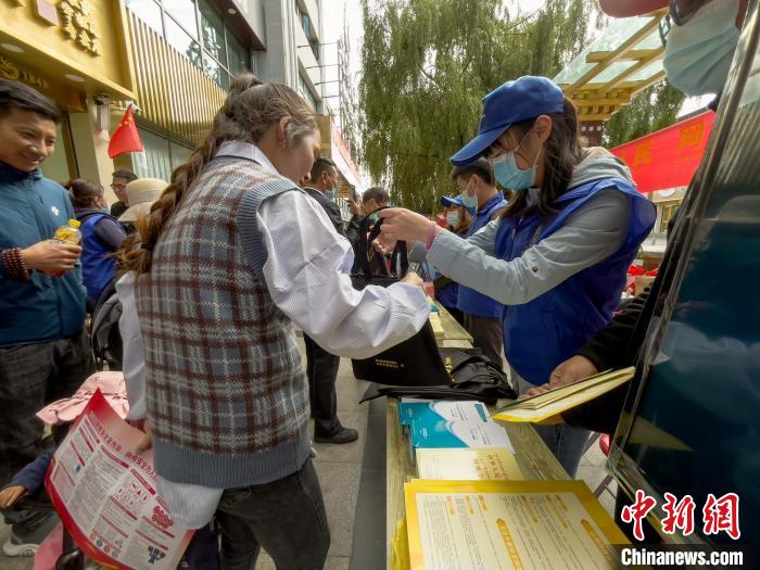 圖為志愿者為市民發(fā)放網(wǎng)絡(luò)安全宣傳手冊(cè)。　謝牧 攝