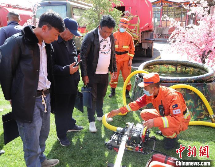 圖為森林消防員為護林員講解滅火裝備的使用方法?！〔际猩窒乐ш?供圖