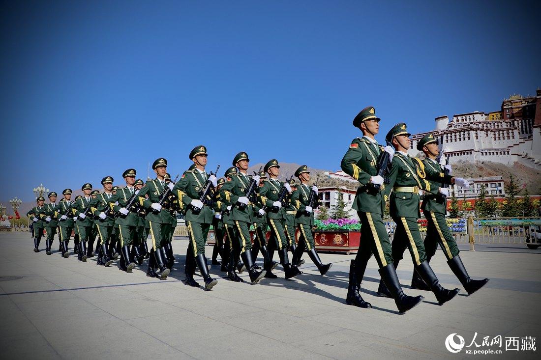 國旗護(hù)衛(wèi)隊隊員緊握鋼槍，踏著威武雄壯的步伐，走向國旗臺。人民網(wǎng) 次仁羅布攝