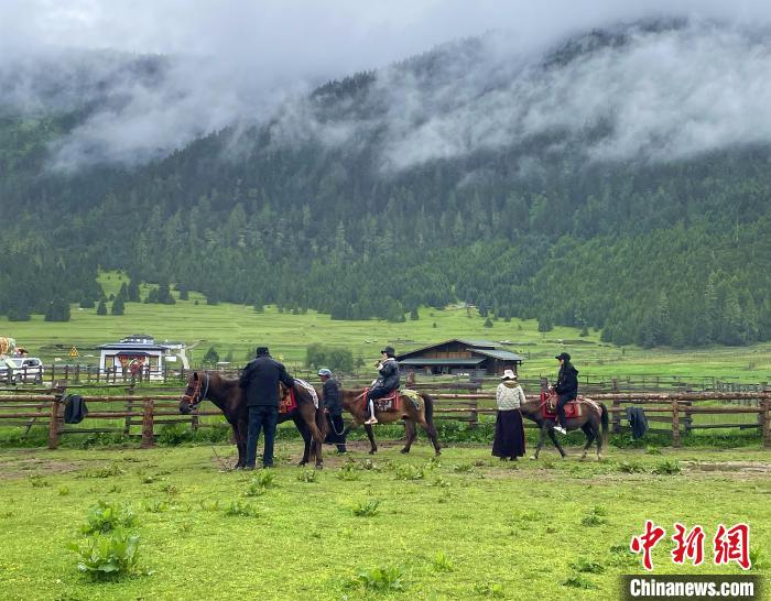 6月10日，游客在魯朗小鎮(zhèn)高山牧場景區(qū)體驗騎馬?！∪轿木?攝