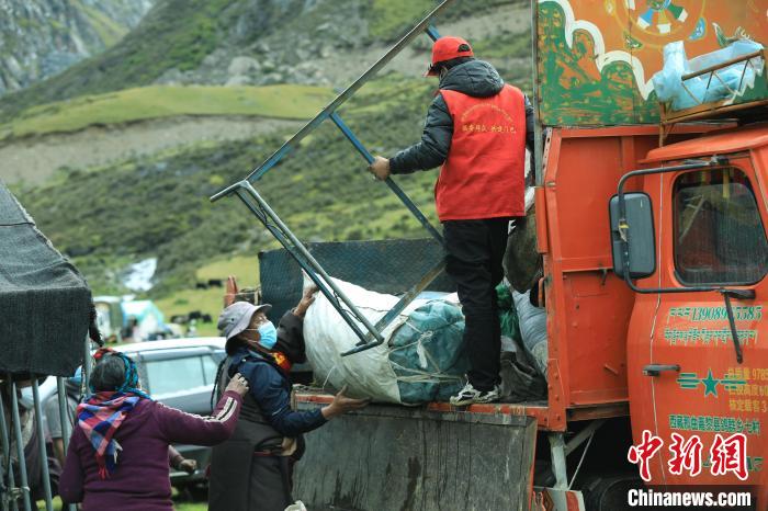 圖為工作人員幫助牧民們卸家具?！÷蹇?攝