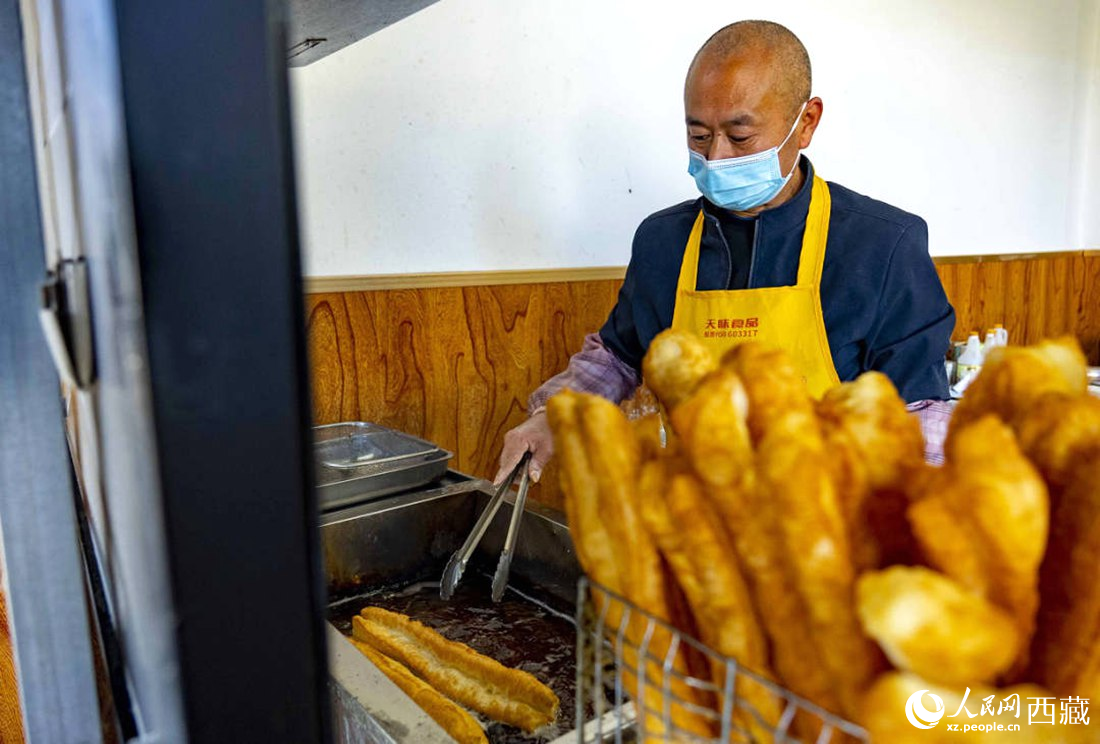 早餐店老板正在炸油條。人民網(wǎng) 次仁羅布攝