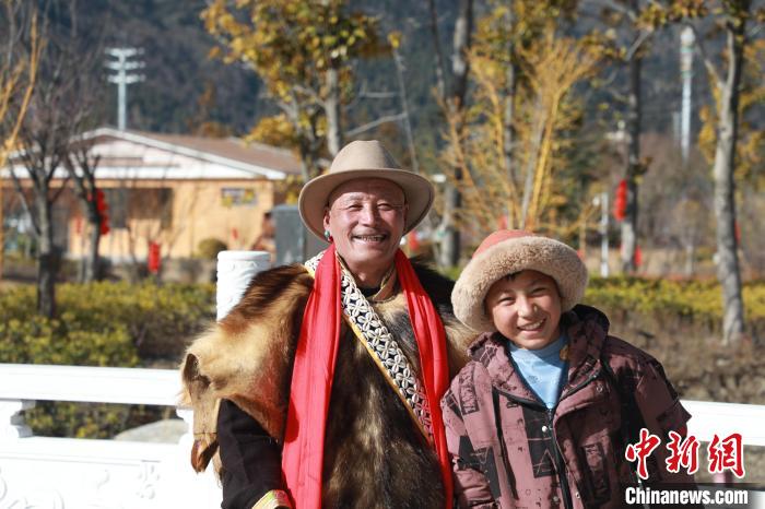 圖為林芝市巴宜區(qū)布久鄉(xiāng)仲果村村民桑杰與孫子一起參加藏歷新年活動?！埩?攝