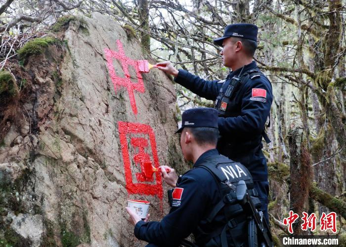 山南邊境管理支隊(duì)玉麥邊境派出所民警邊境巡邏途中在石頭上用油漆涂寫(xiě)“中國(guó)”二字 。　鄭琦山 攝