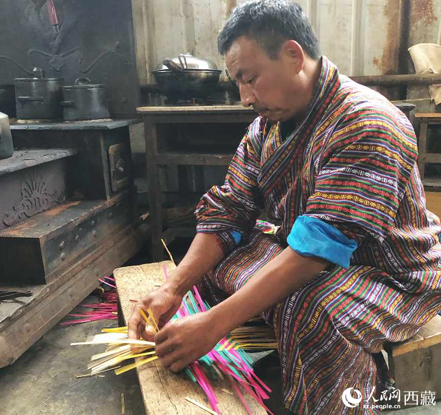 門巴族漢子愛明正在編織藤竹品。