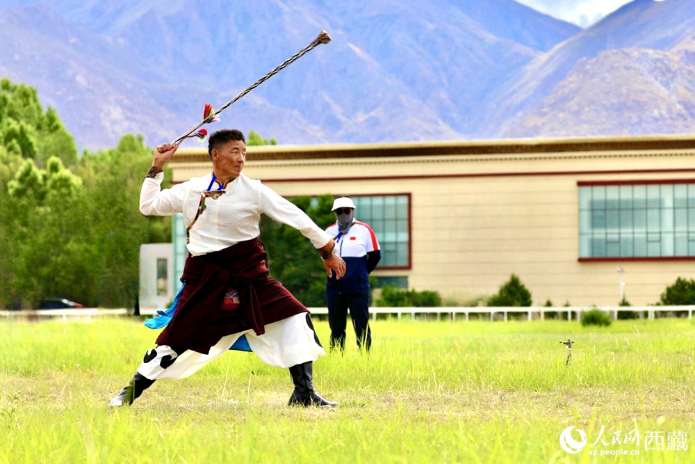 參賽選手在拉薩首屆農(nóng)牧民運(yùn)動(dòng)會(huì)上進(jìn)行“古朵”比賽（“古朵”指的是用牦牛毛或者山羊毛編織成的拋石繩，可以將石頭投擲到較遠(yuǎn)的地方，是牧民們用來放牧的工具）。