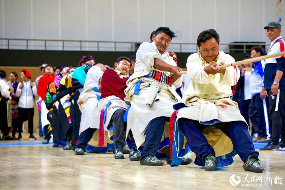 身著民族服裝的農(nóng)牧民選手在拔河比賽現(xiàn)場。